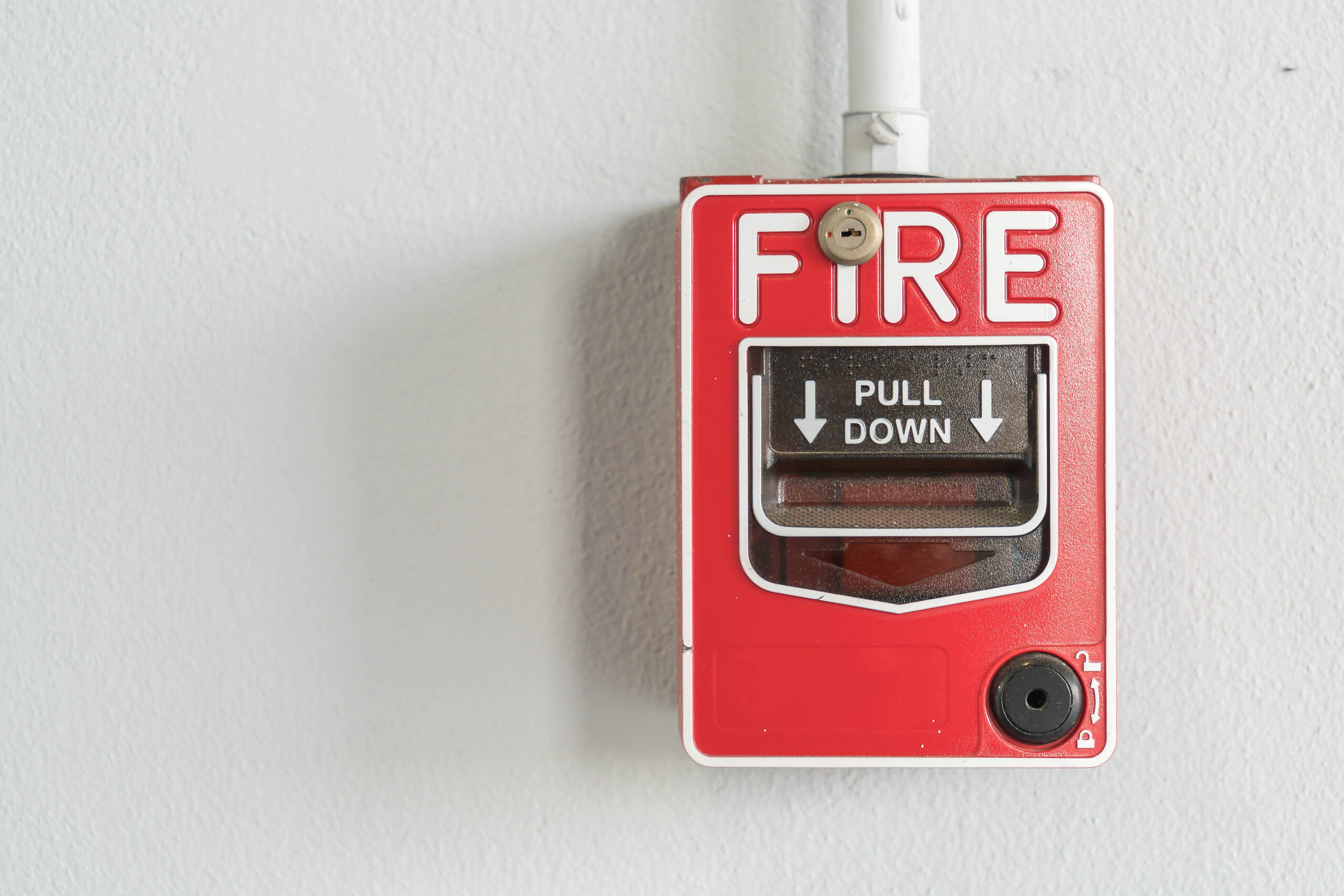 Fire alarm switch on white wall